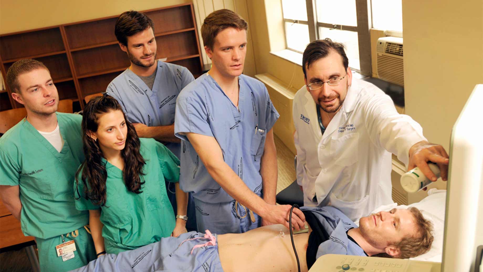 health care students looking at computer image with professor